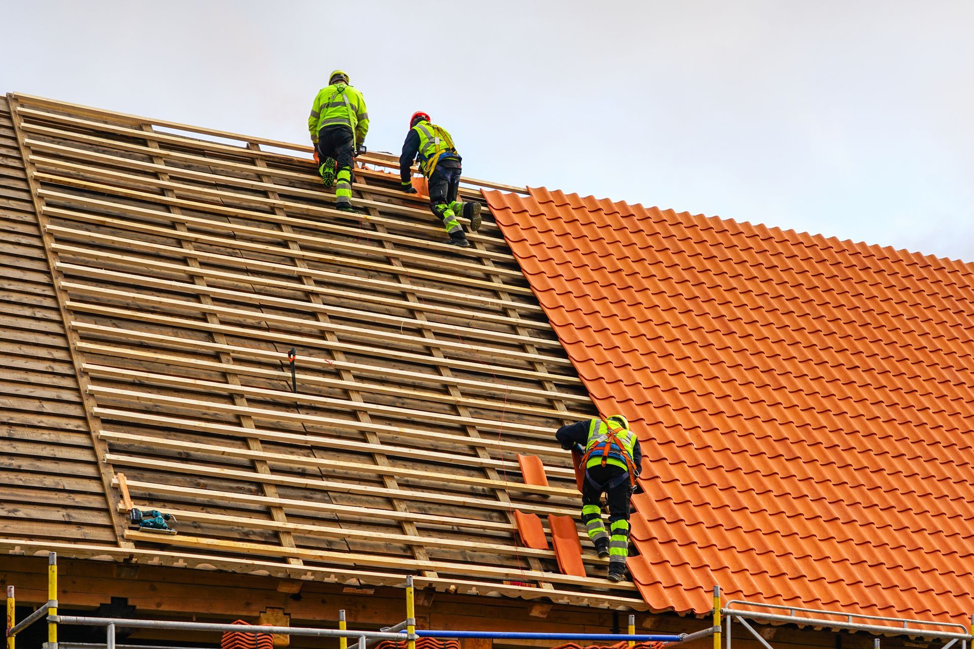 A group of construction workers are working on a roof.