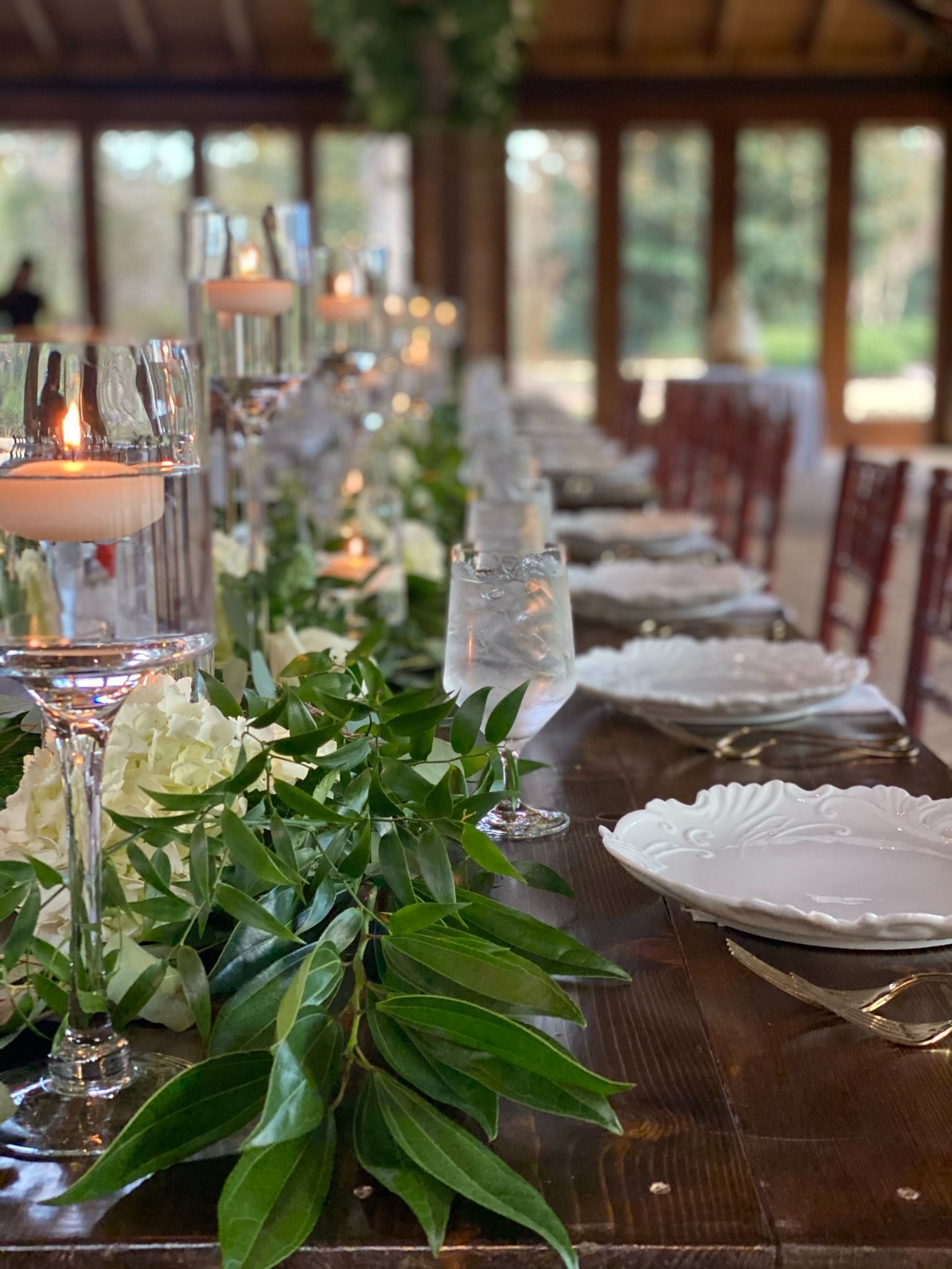 wedding reception centerpiece with floating candles and greenery