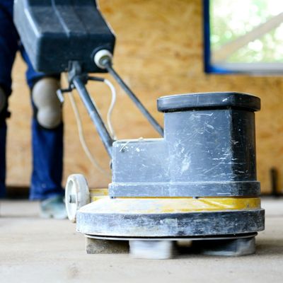 A person is using a machine to sand a wooden floor.
