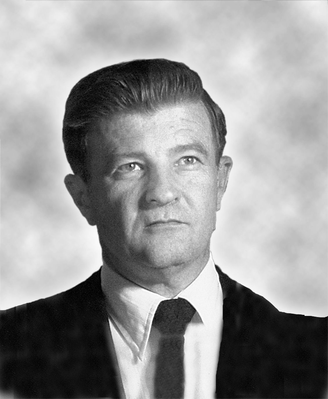 A black and white photo of a man in a suit and tie