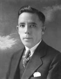 A black and white photo of a man in a suit and tie