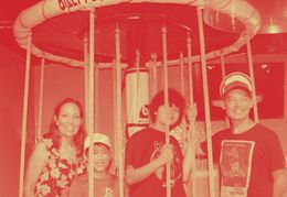 A family is posing for a picture in front of a slide.
