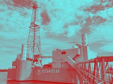 A red and blue photo of an ocean star oil rig