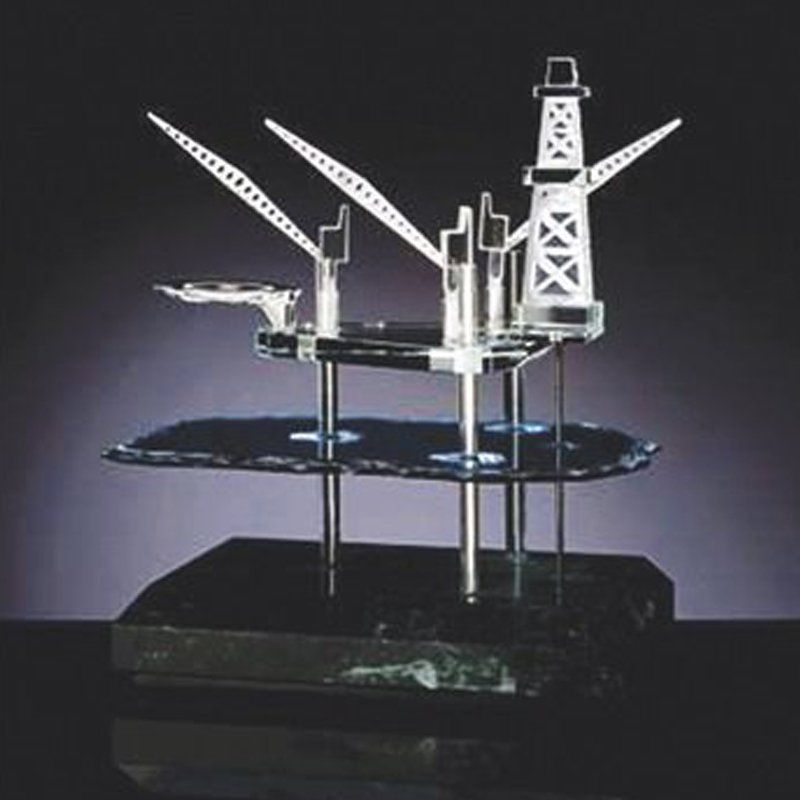 A glass sculpture of an oil rig on a black base