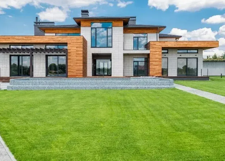 A large house with a lush green lawn in front of it.