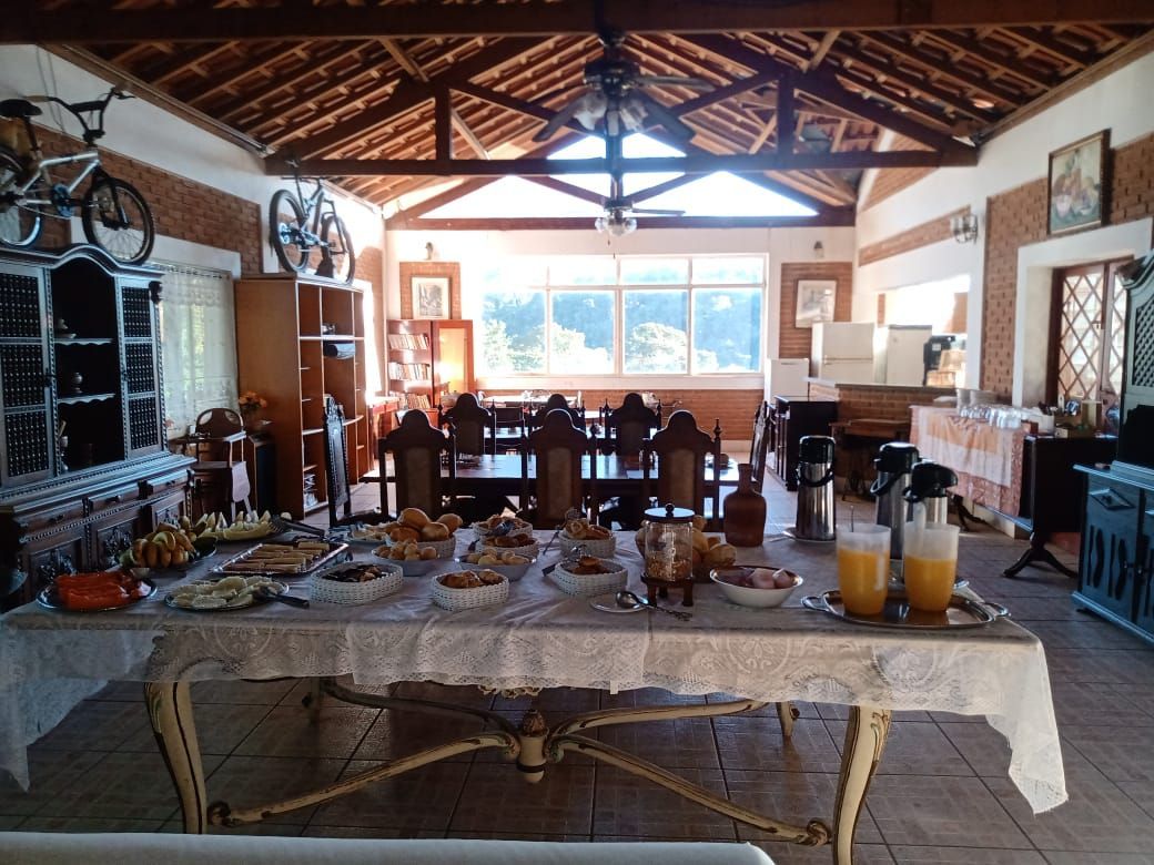 Buffet de café da manhã em um salão amplo com uma mesa comprida. Comida exposta