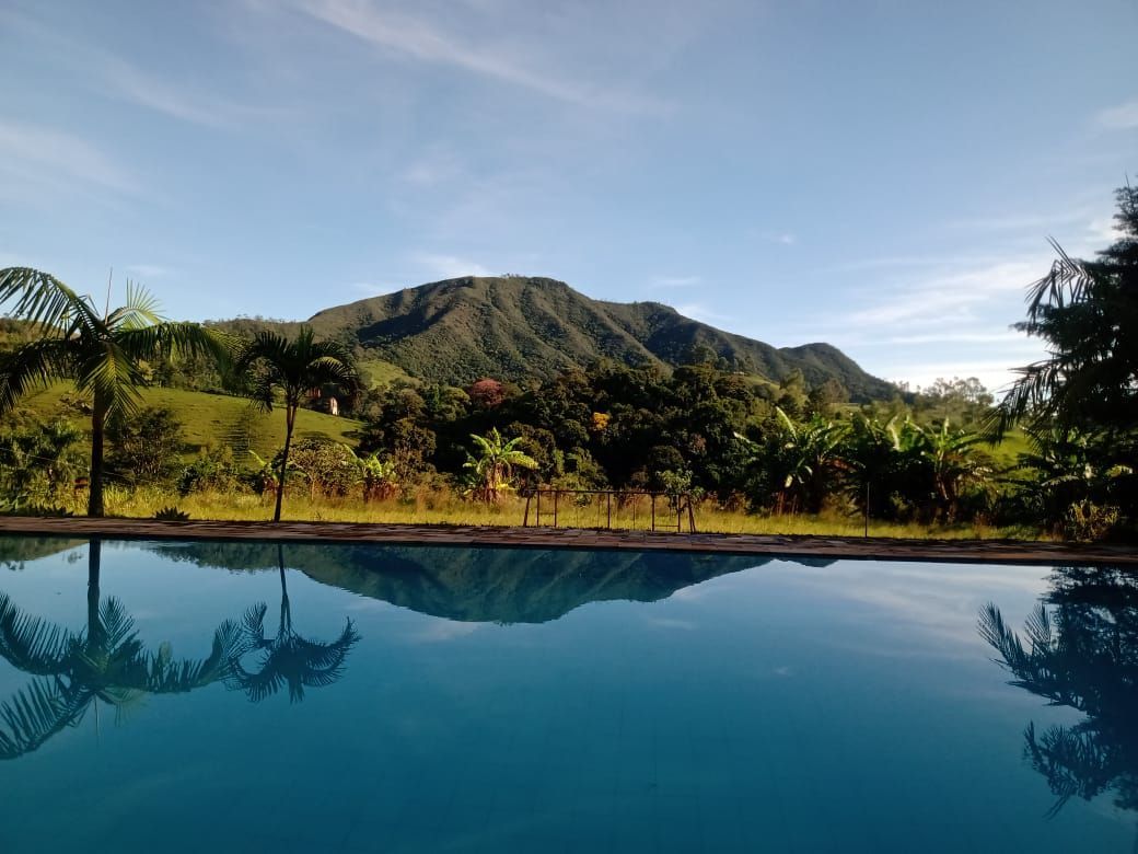 Uma montanha refletida em uma piscina infinita de águas cristalinas e azuis em um dia ensolarado.