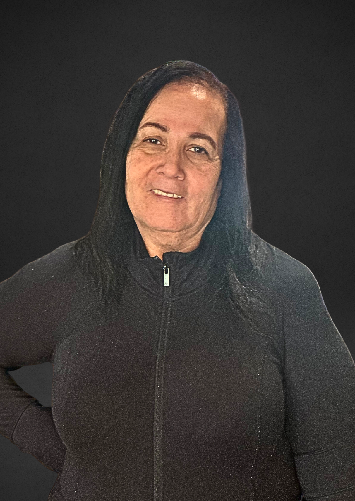 Woman in dark zip-up smiling, against a blurred black background.