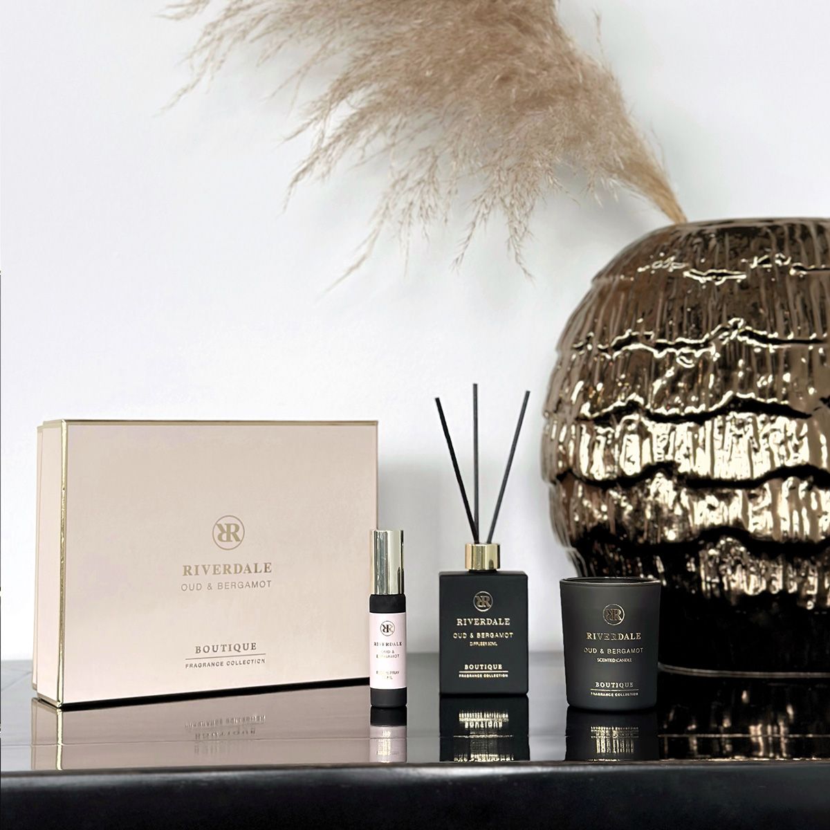 Roze luxe geurgeschenkset met diffuser, kaars en parfumflesje op een witte achtergrond