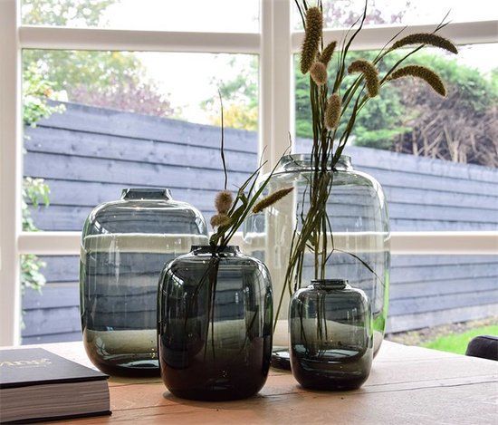 Een vaas met kleurrijke bloemen op een tafel voor een stenen muur met open haard.