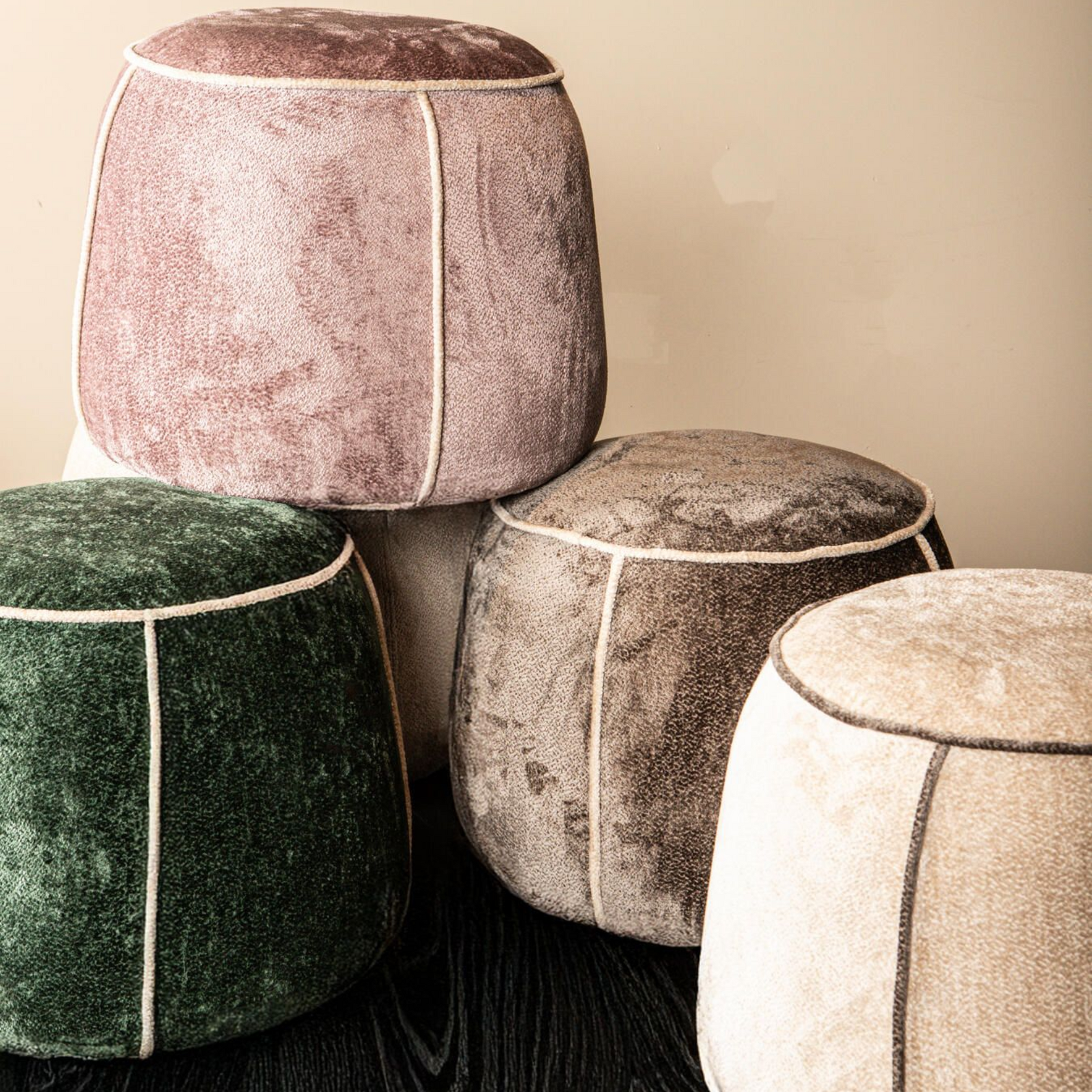 Donkergroene, ronde poef met lichte bies.