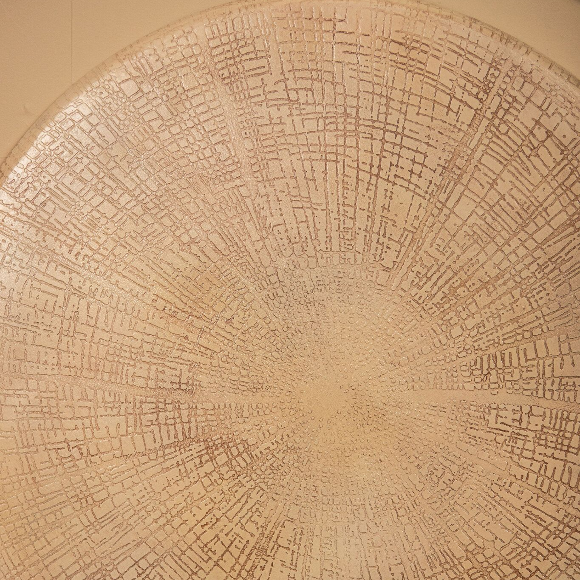 Woonkamer met beige muren, decoratie zoals ronde wanddecoratie, vazen en een bank.