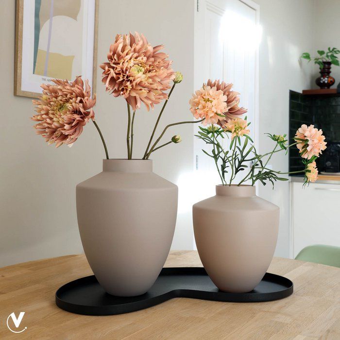 Beige, druppelvormige vaas met een smalle hals, op een witte achtergrond.