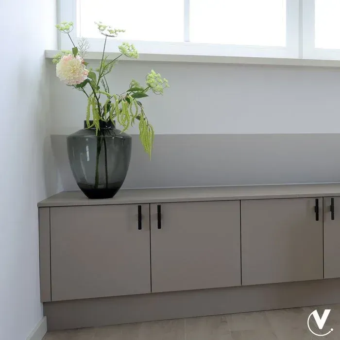 Grijze glazen vaas met een ronde vorm, een donkere rand en een kleurverloop van een donkere basis naar een lichte bovenkant.