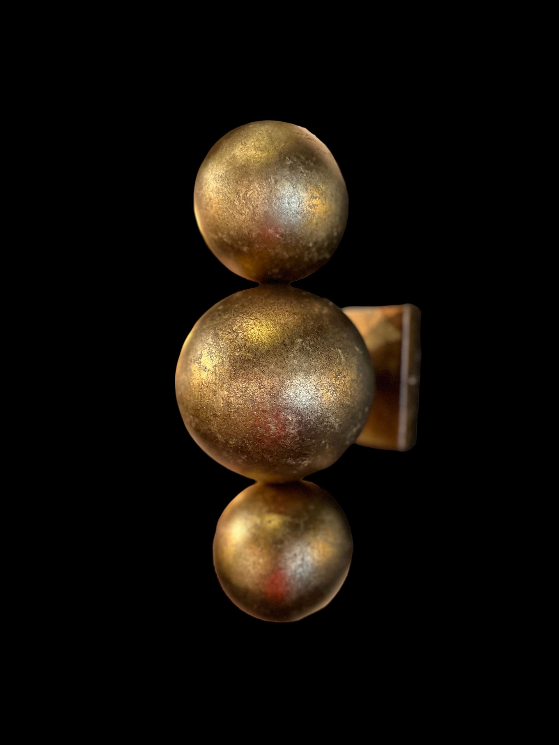 Goudkleurige wandlamp met drie verticaal gestapelde bollen.