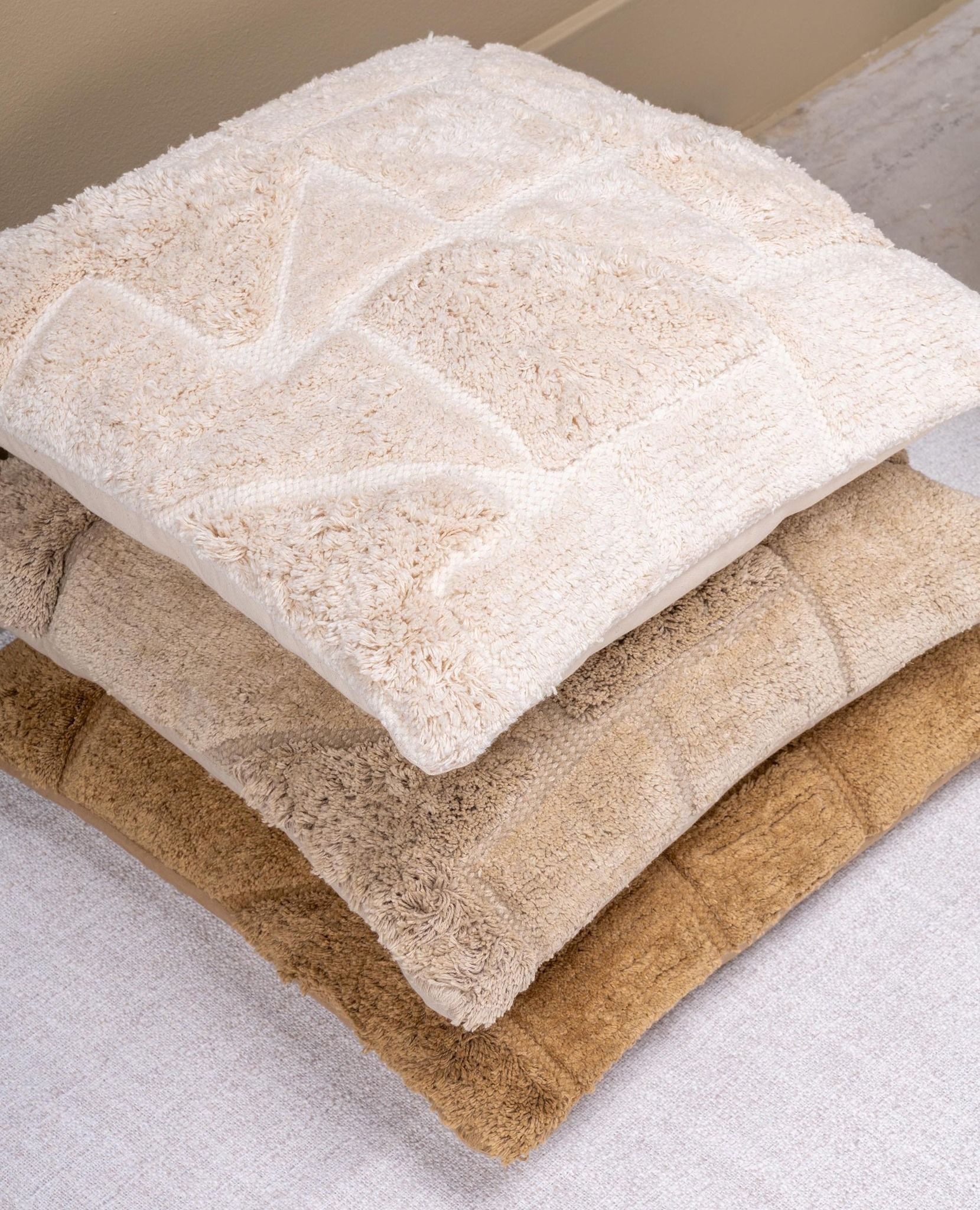 Bruin, vierkant kussen met textuur en geometrisch patroon.