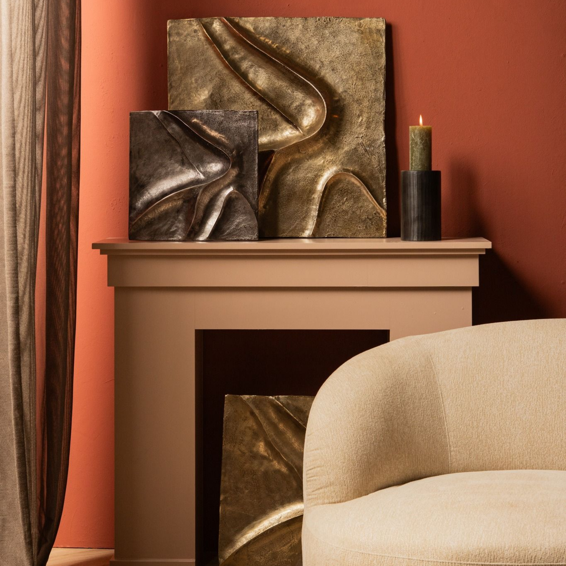 Een kamer met kunst op de schoorsteenmantel, een comfortabele stoel en een kleurenpalet in aardetinten.