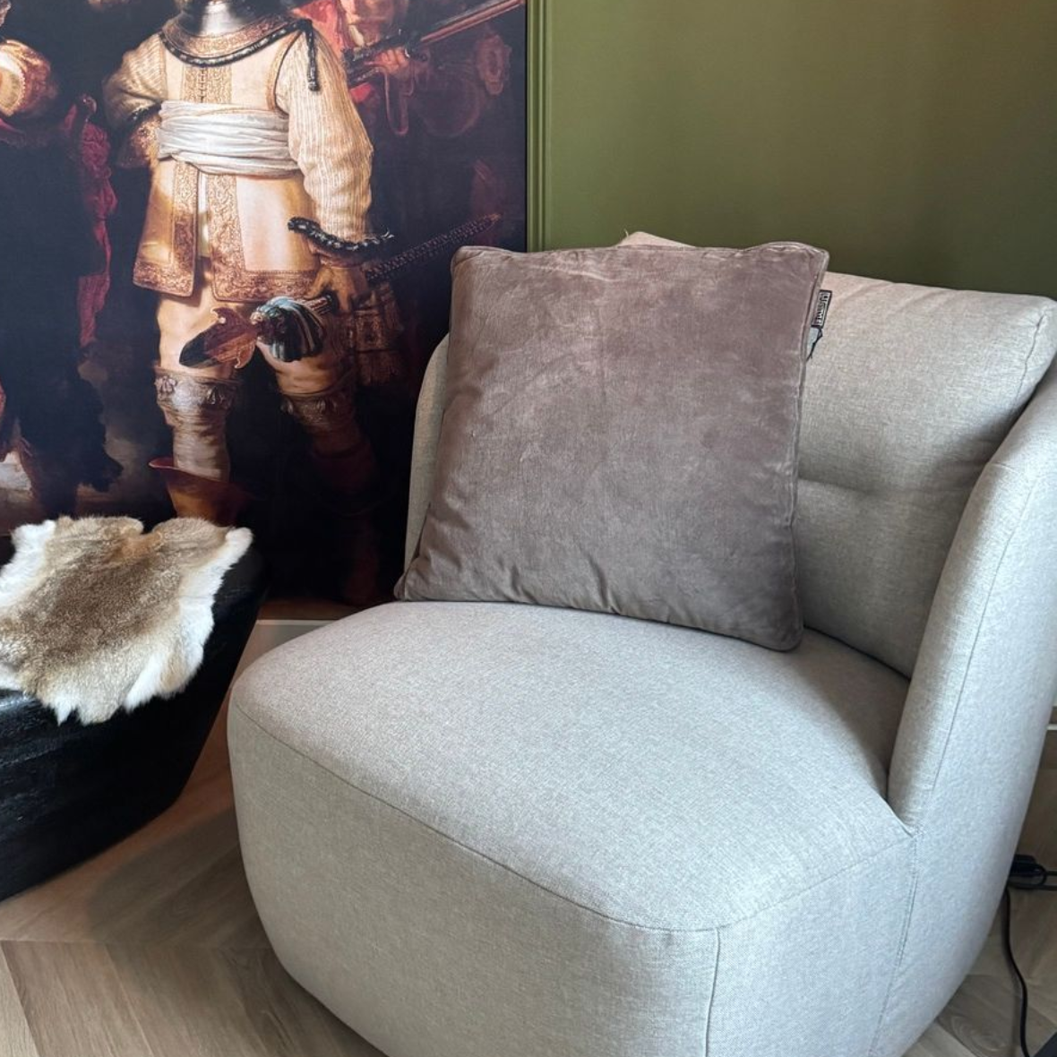 Een licht grijs/lichtbruin kussen op een stoel