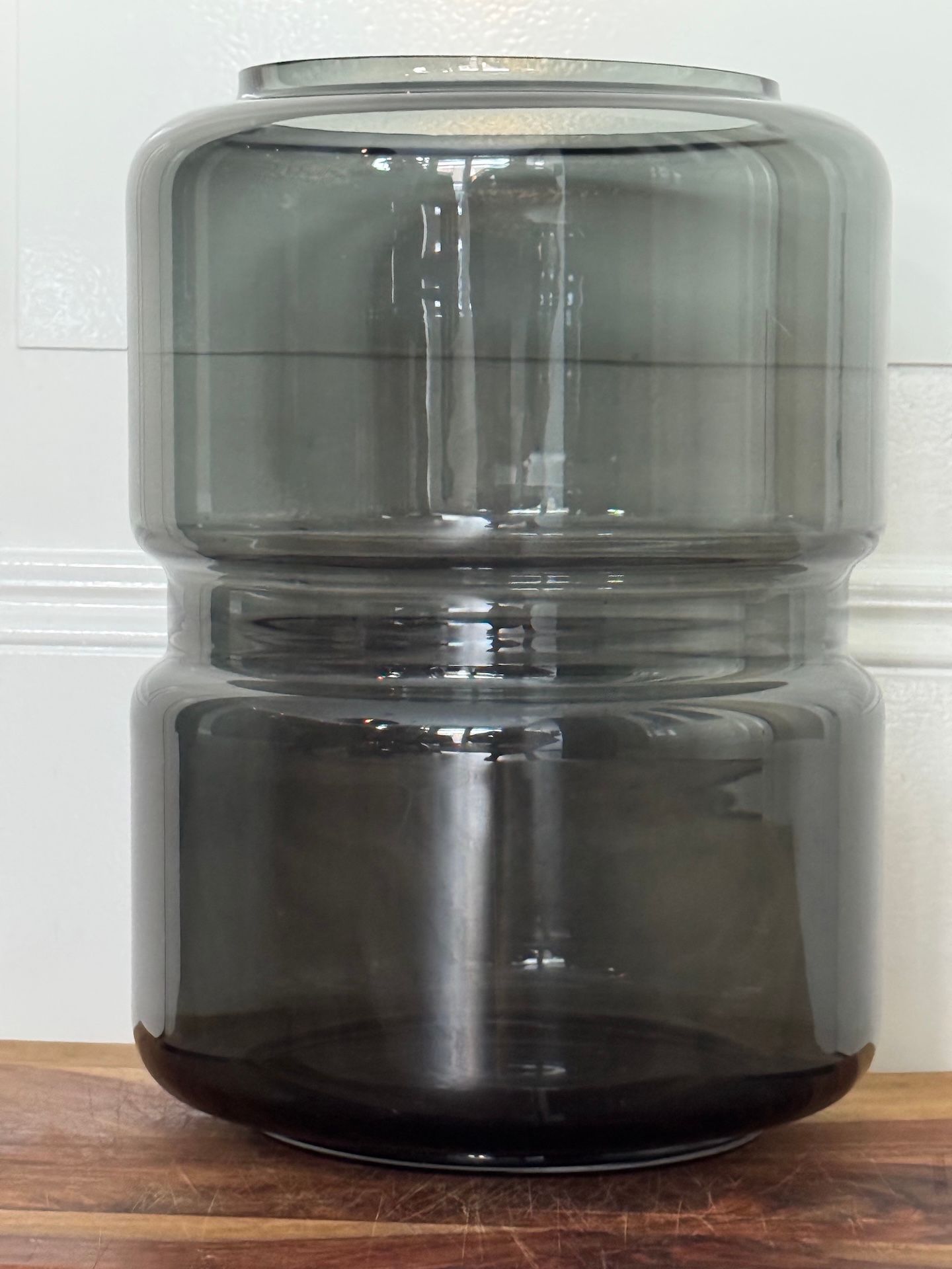 Grijze glazen vaas met cilindrische segmenten.