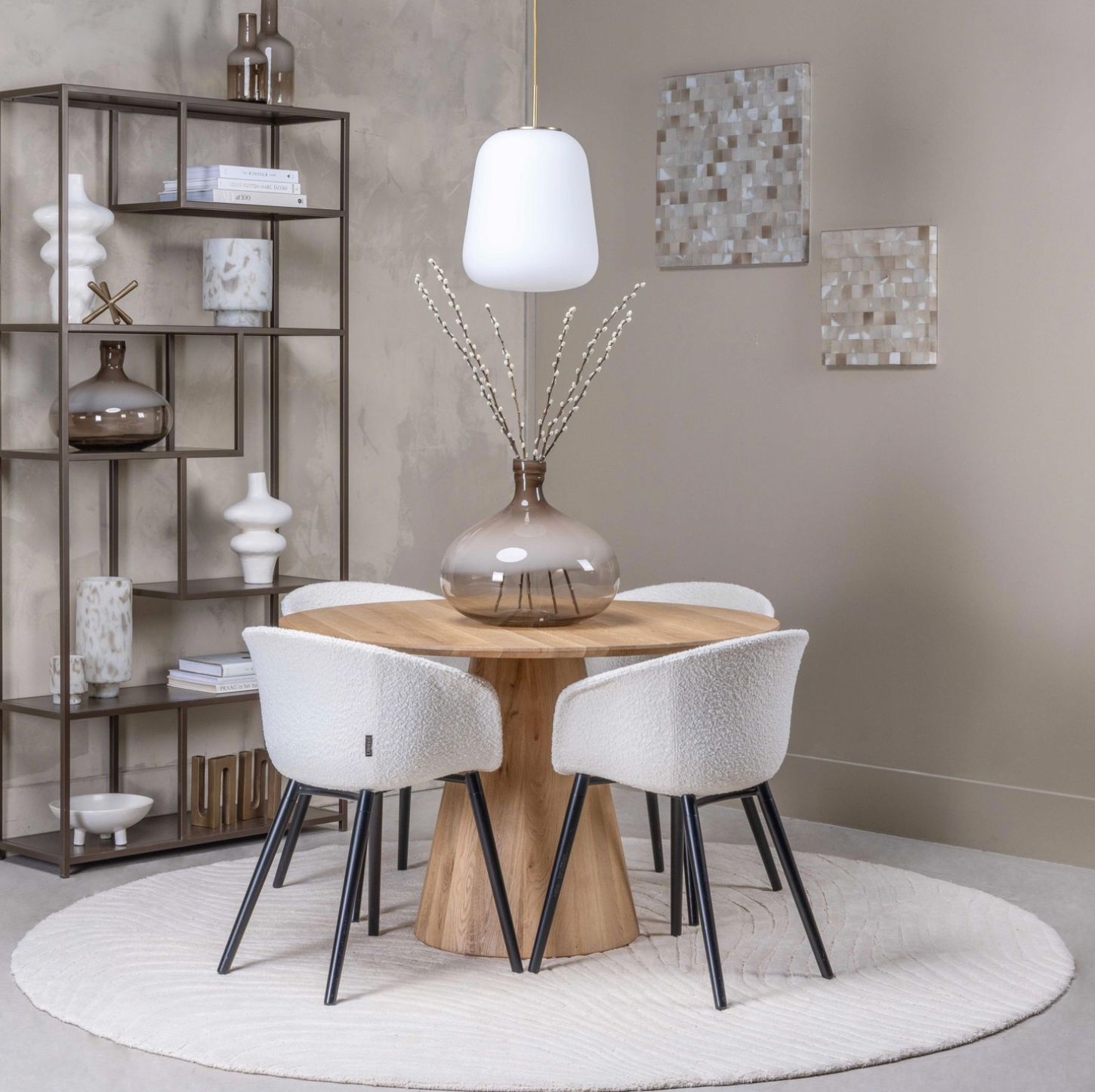 Moderne woonkamer met donkere planken waarop sculpturen en decoraties staan, naast een beige bank.