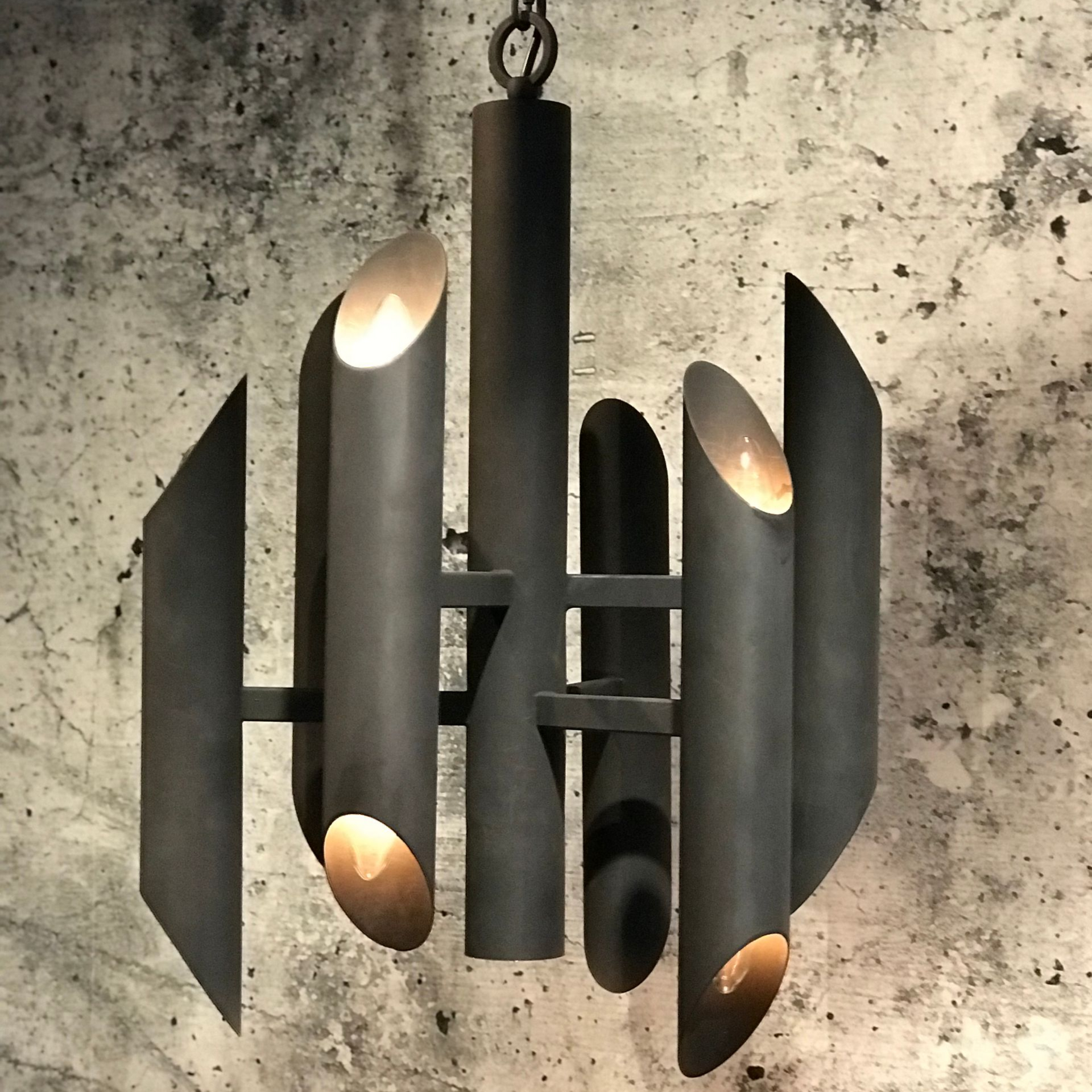 Donkere metalen kroonluchter met buisvormige lampen.