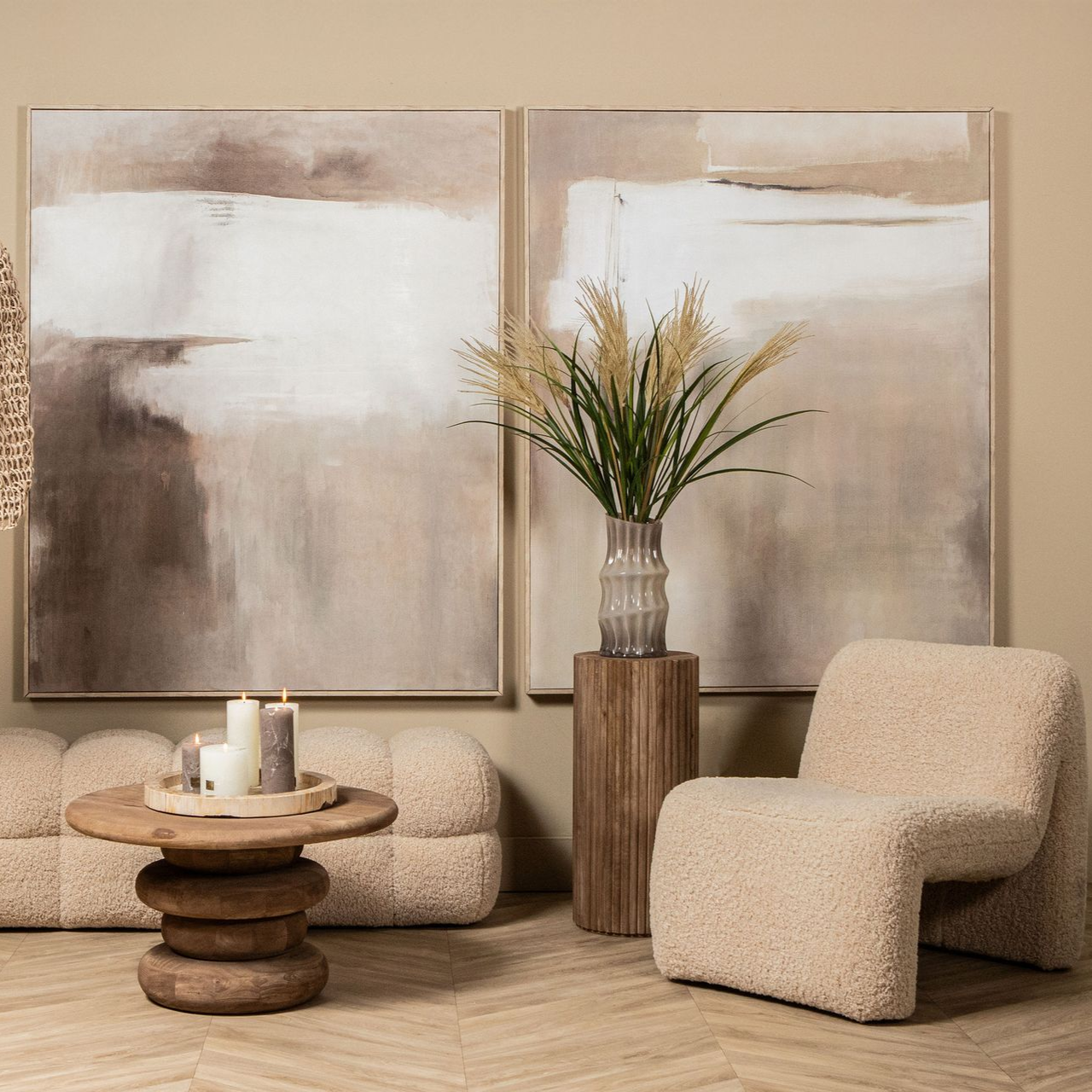 Een gezellige woonkamer met een neutraal kleurenschema. Kunstwerken, een stoel, een voetenbankje en een vloerkleed.