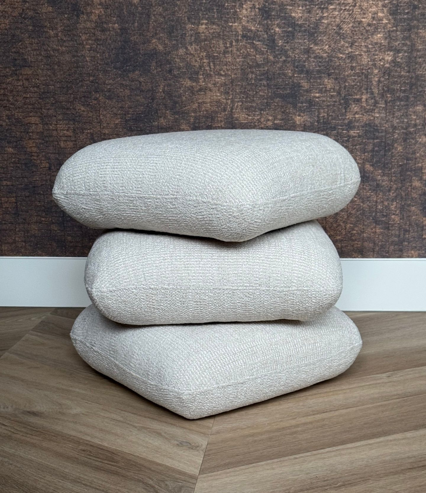 Draaibare creme poef met drie lagen.