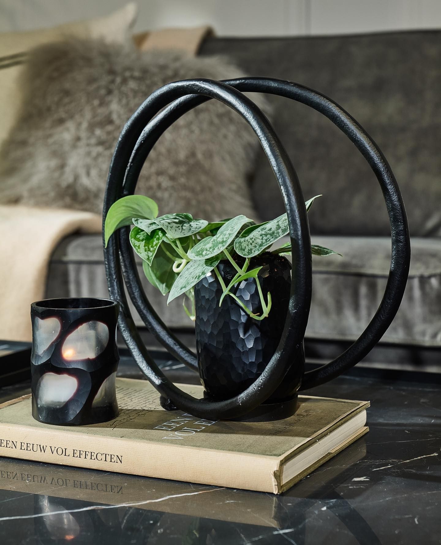 Zwarte metalen kaarsenhouder met twee gebogen ringen.