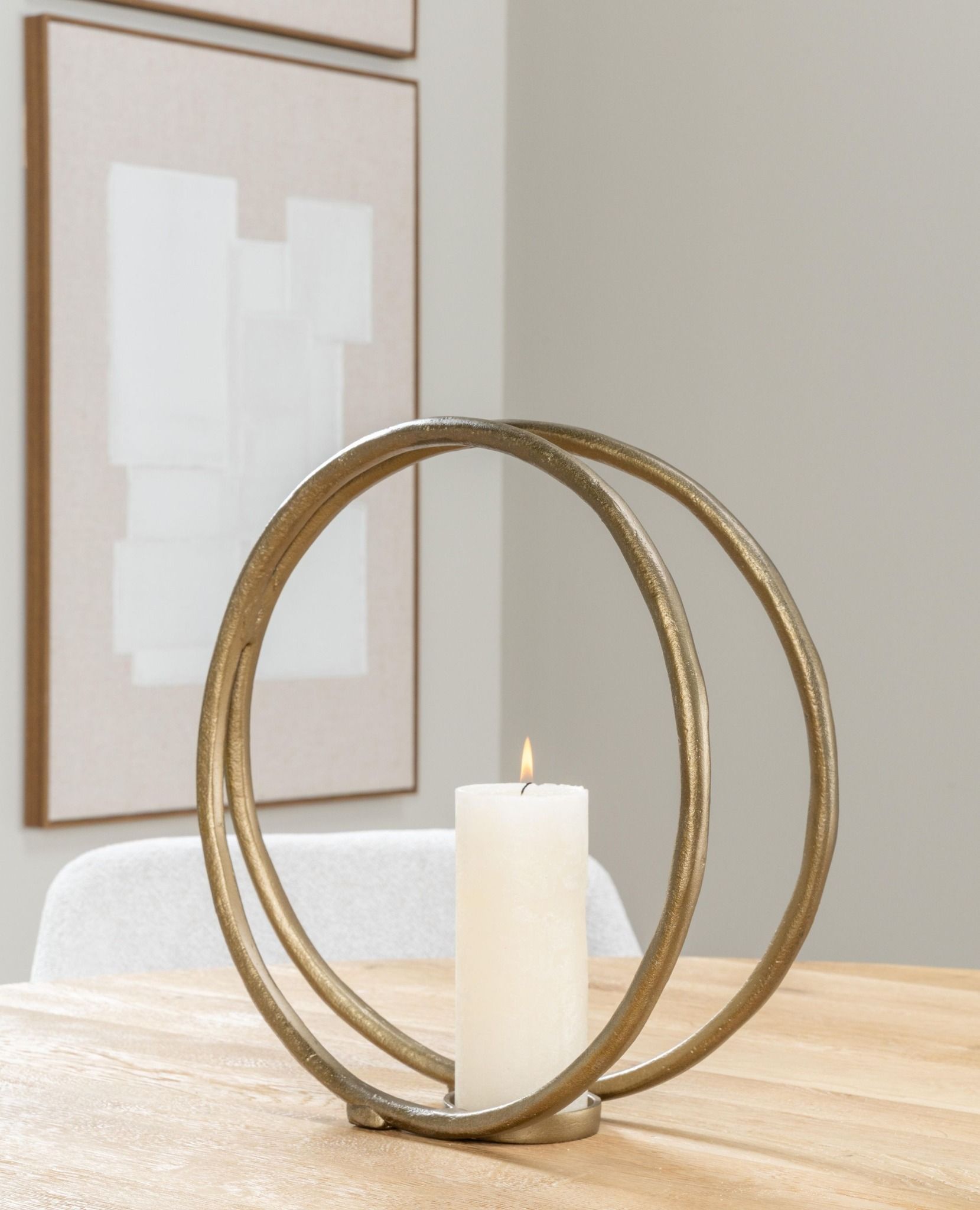 Goudkleurige ronde ringen, die aan de onderkant met een kleine sluiting aan elkaar zijn bevestigd.