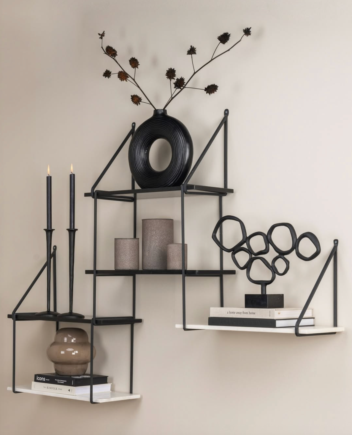 Abstracte sculptuur van zwart metaal op een zwarte marmeren ondergrond.