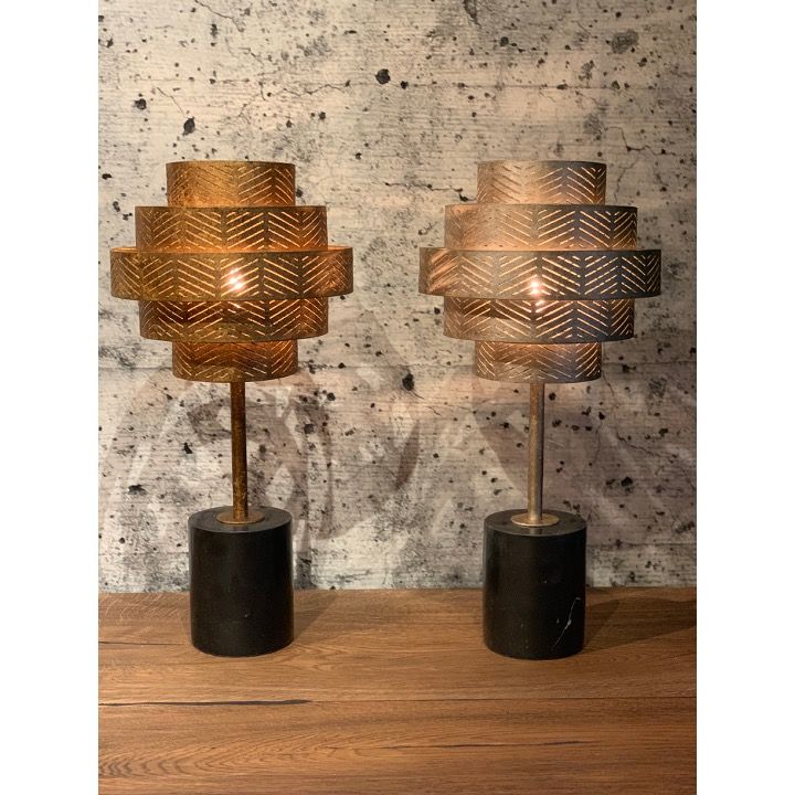 Gouden metalen lamp met meerdere lagen en een zwarte cilindrische voet.