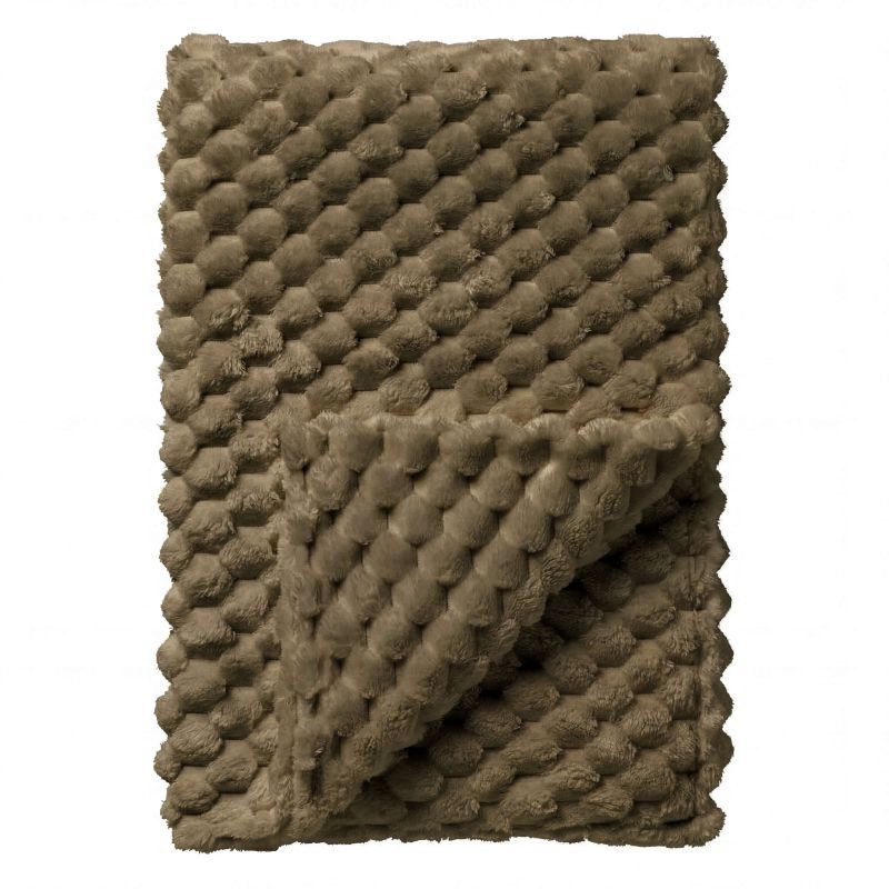 Een opgevouwen, zachte, beige deken met pompons, bijeengebonden met een donker lint.