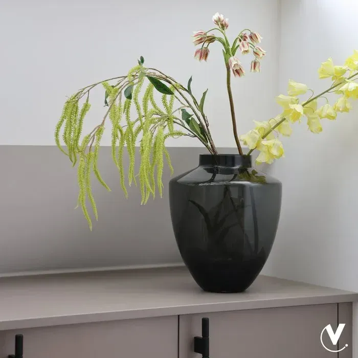 Grijze glazen vaas met een ronde vorm, een donkere rand en een kleurverloop van een donkere basis naar een lichte bovenkant.