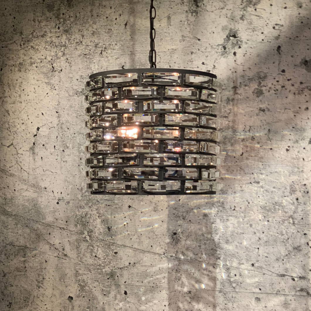 Zwarte, cilindrische kroonluchter met rechthoekige kristallen accenten.