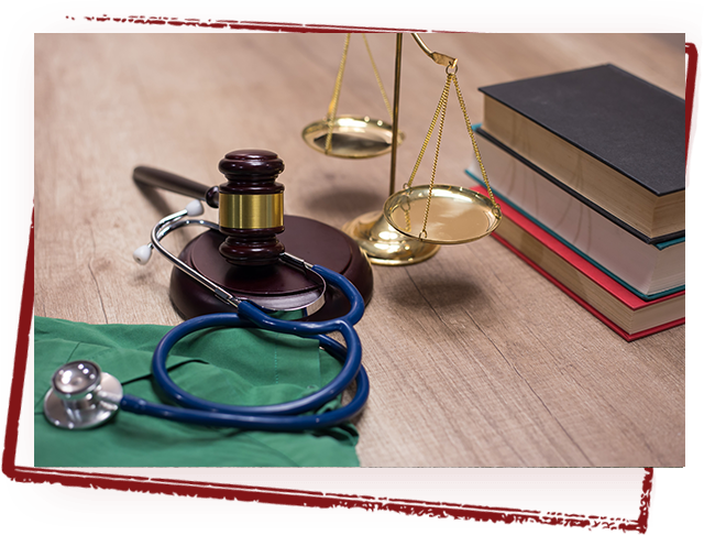 Gavel, stethoscope and golden scale on a table, representing personal injury lawer services.