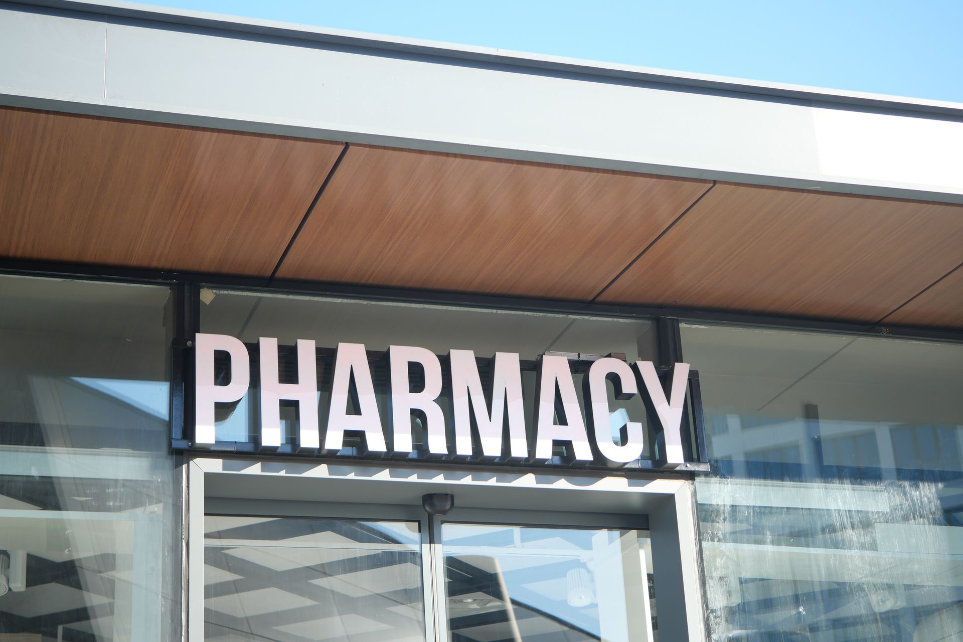 A colorful building background with a visible pharmacy sign in an urban street view.