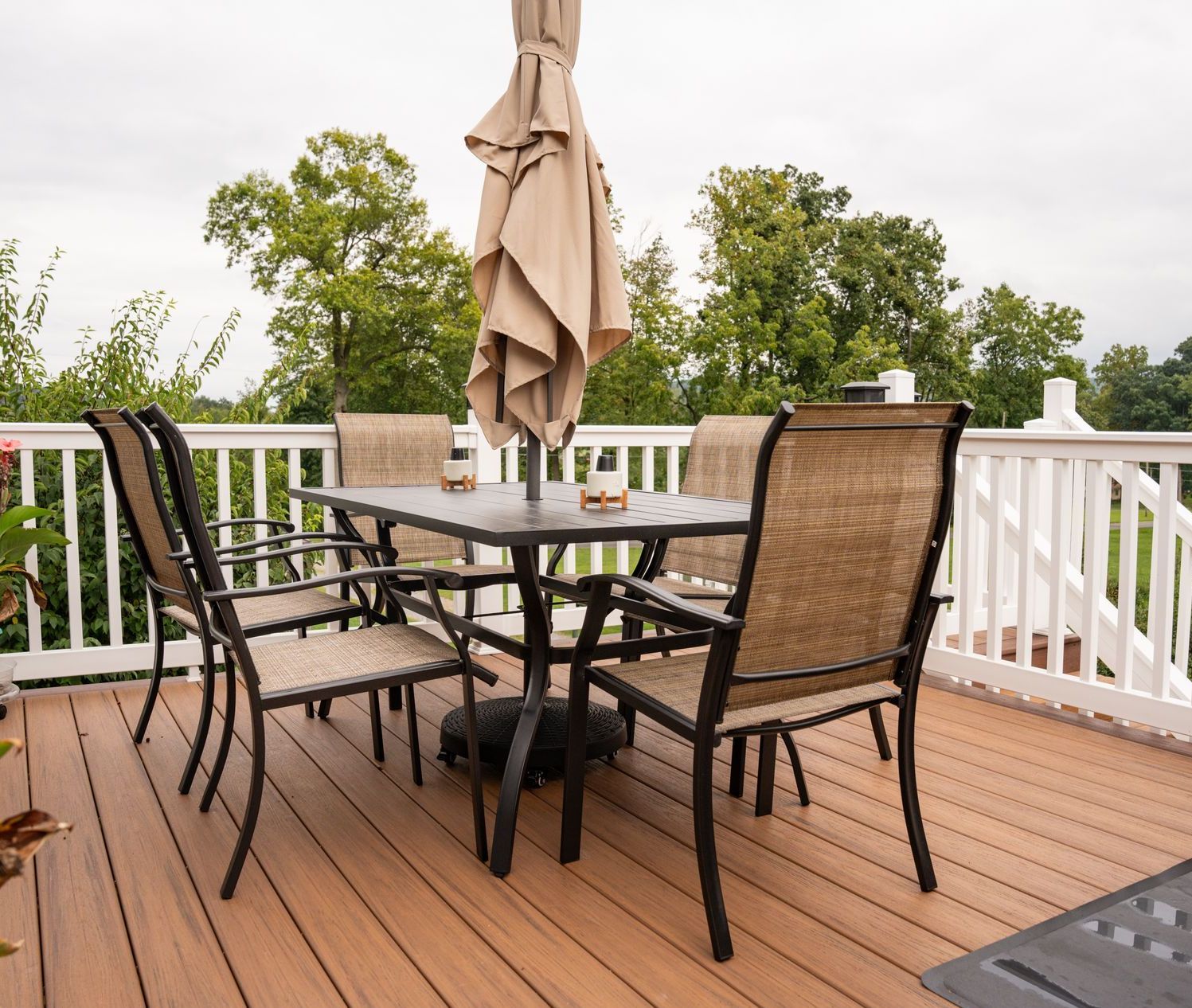 There is a table and chairs on the deck with an umbrella.