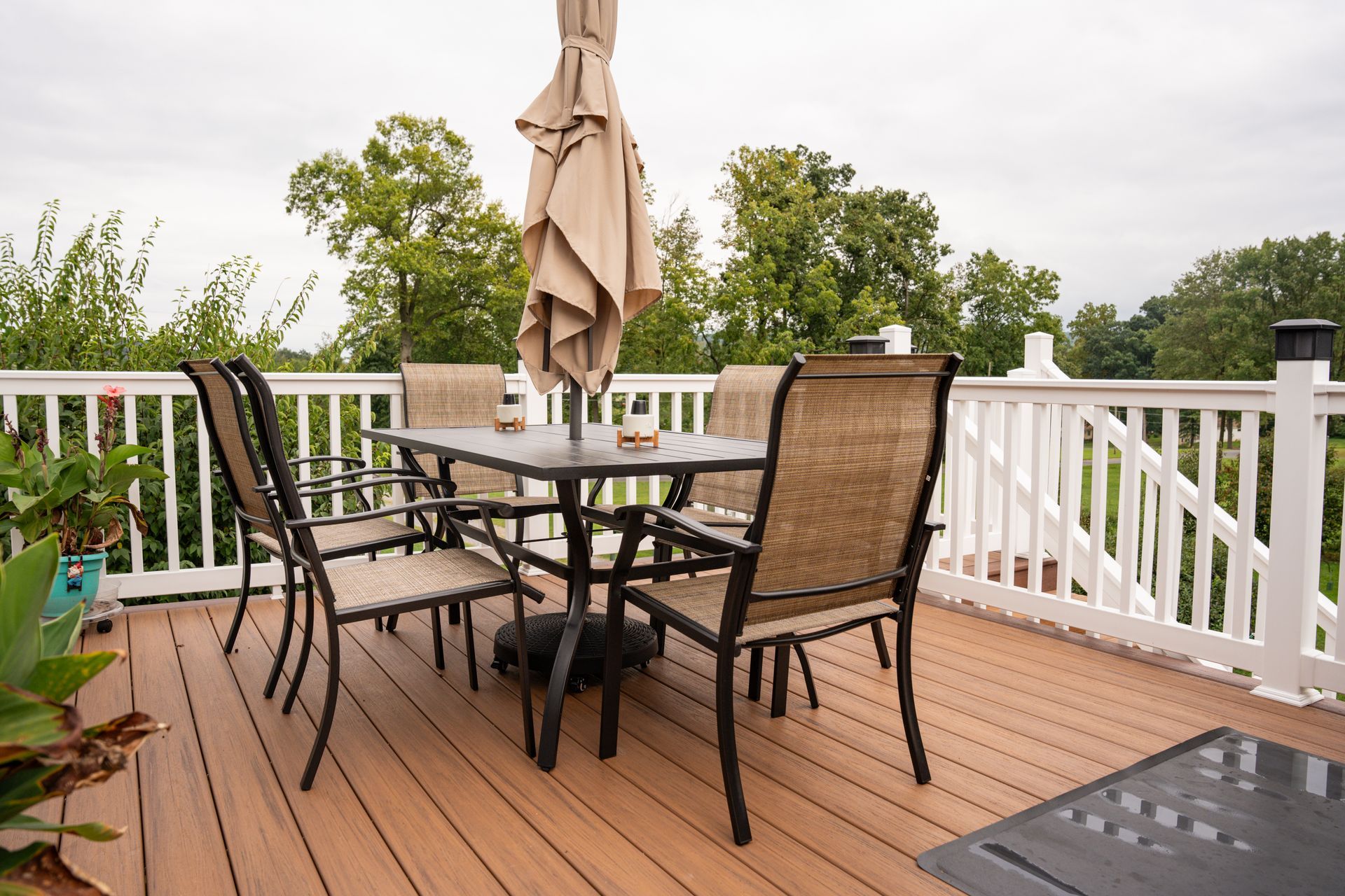 There is a table and chairs on the deck with an umbrella.