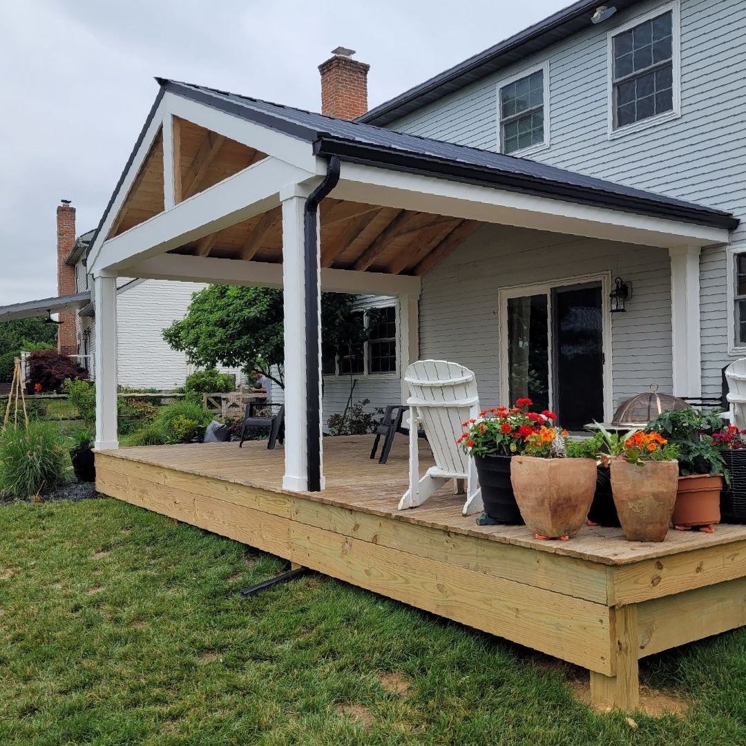 A deck with a white railing and a chair on it