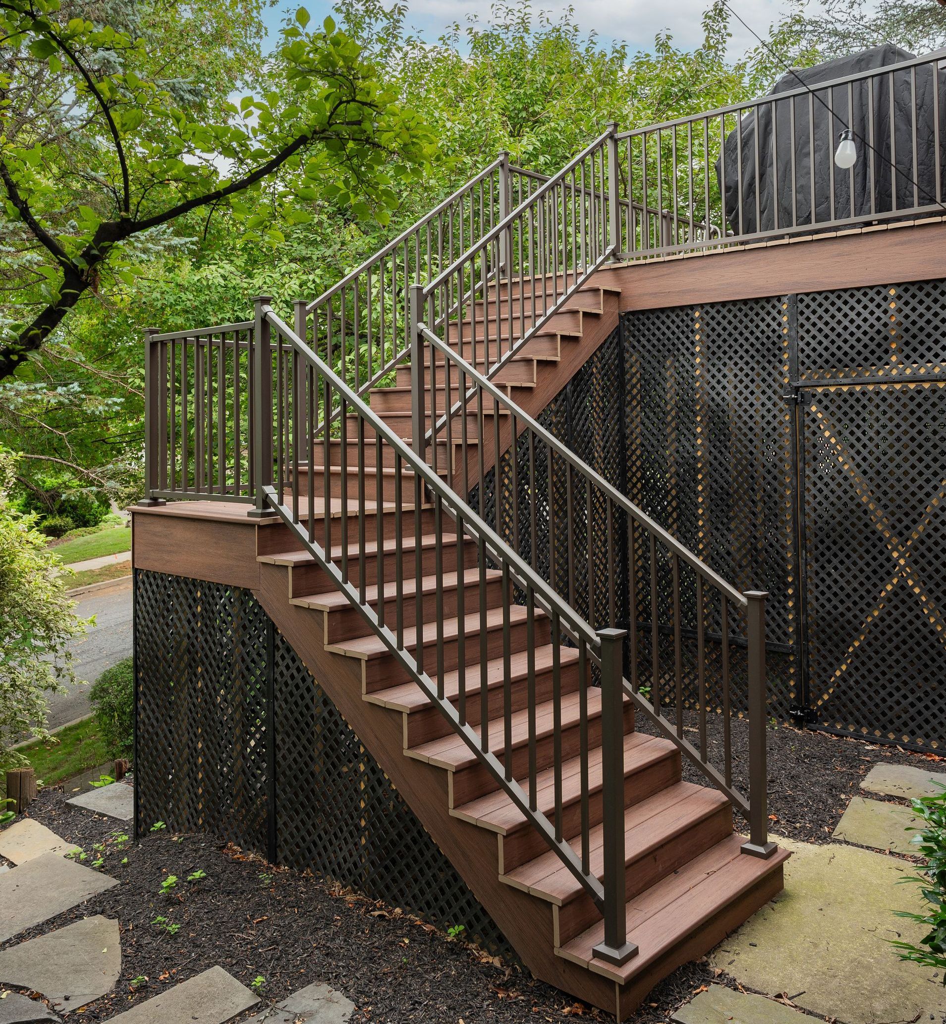 A set of stairs leading up to a deck with a metal railing.