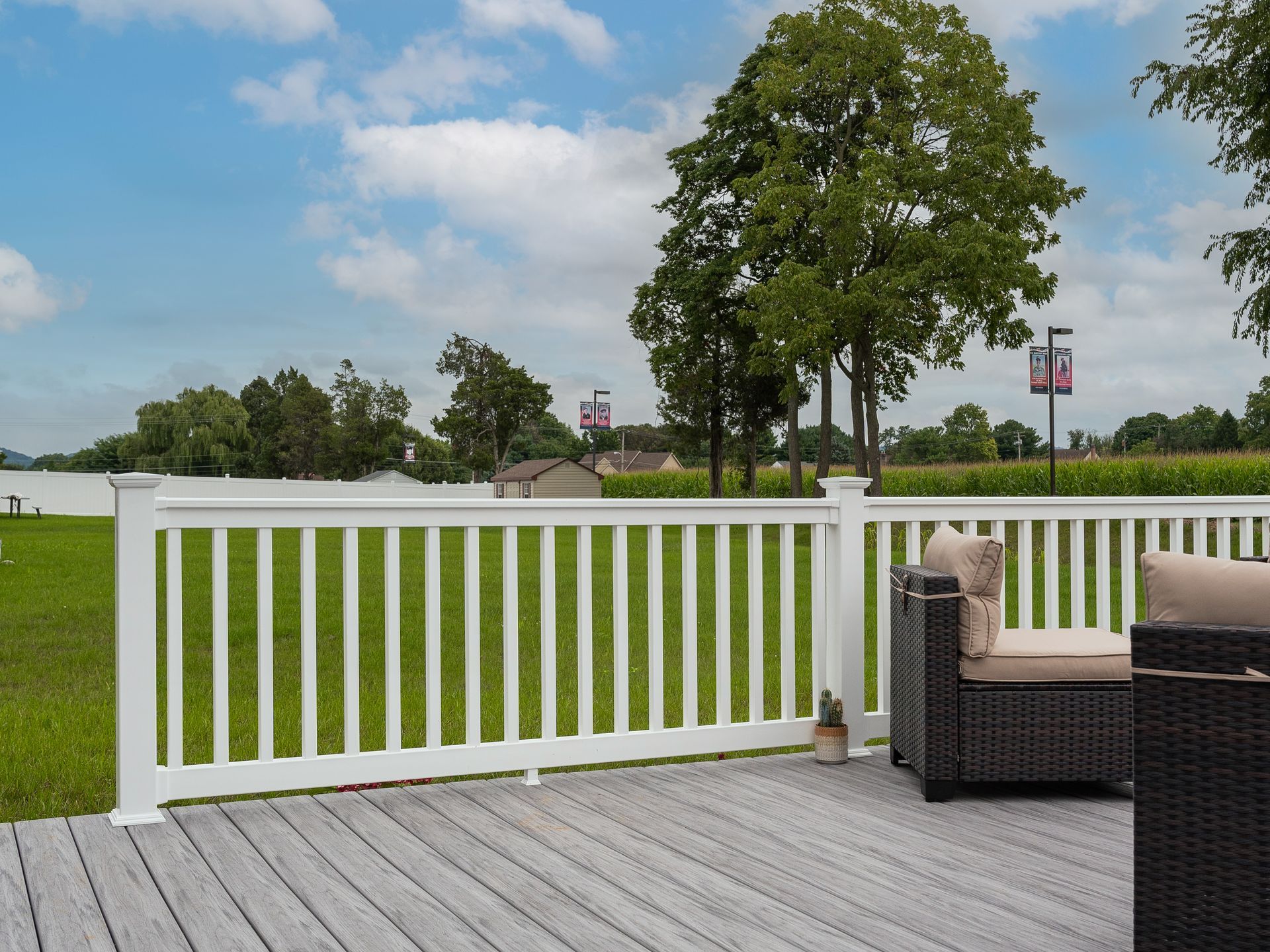 A deck with a white railing and a chair on it