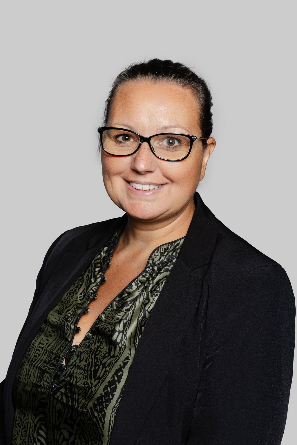 Une photo en noir et blanc d'une femme portant des lunettes et une veste.