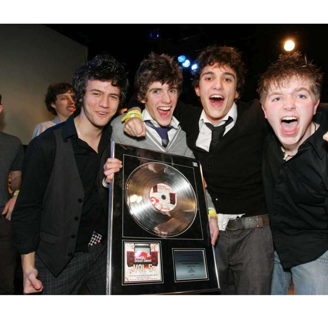 A group of young men are posing for a picture while holding a plaque