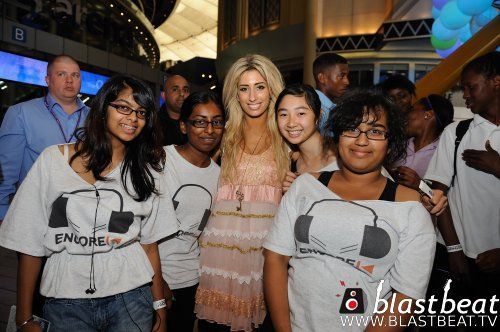 A group of people posing for a picture with a woman wearing headphones t-shirts
