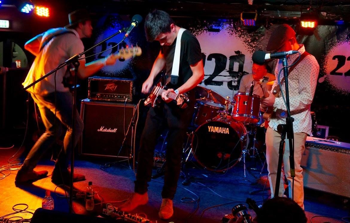 A group of people are playing instruments on a stage in front of a sign that says 29
