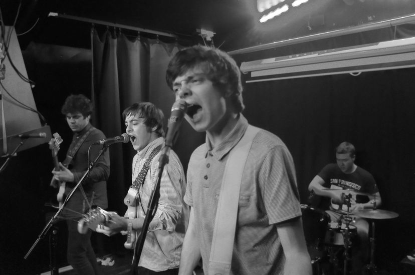 A man singing into a microphone in a band