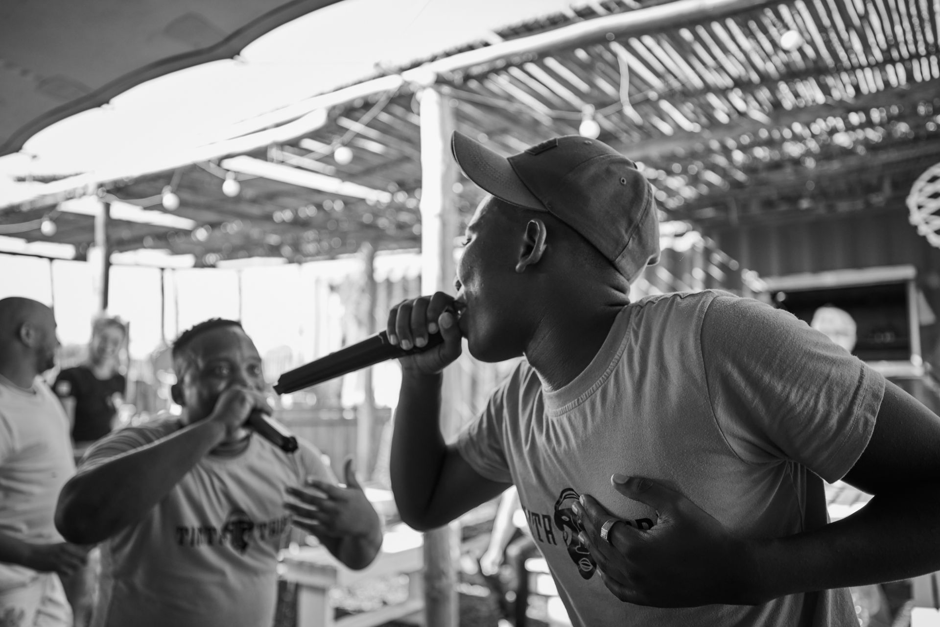 A man is singing into a microphone in a black and white photo.