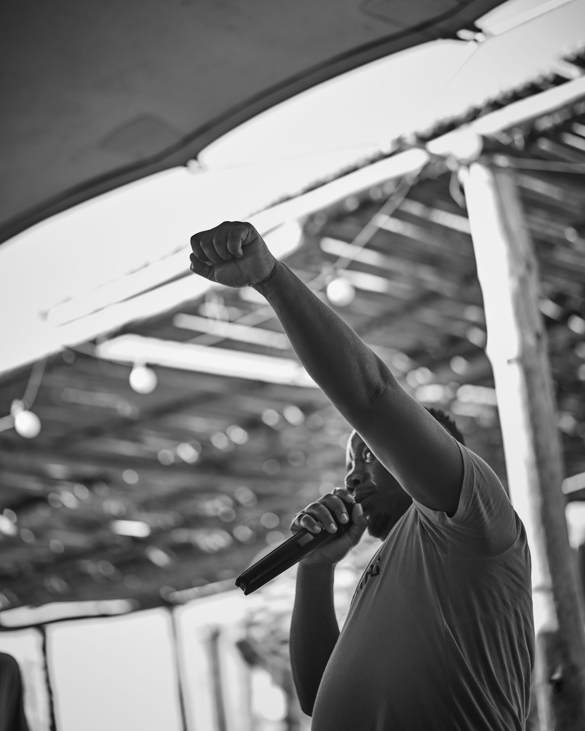 A man is singing into a microphone in a black and white photo.