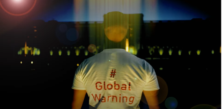 A man wearing a white shirt that says global warning