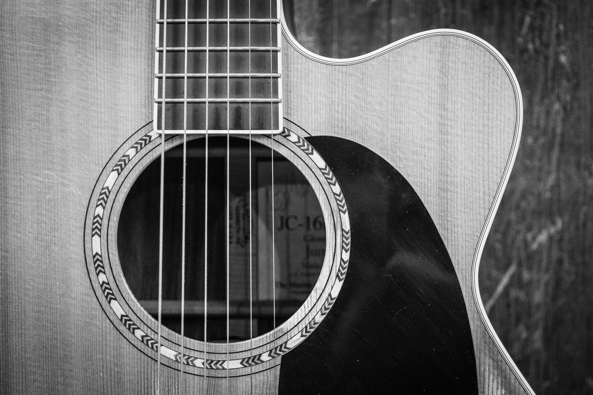 A black and white photo of an acoustic guitar